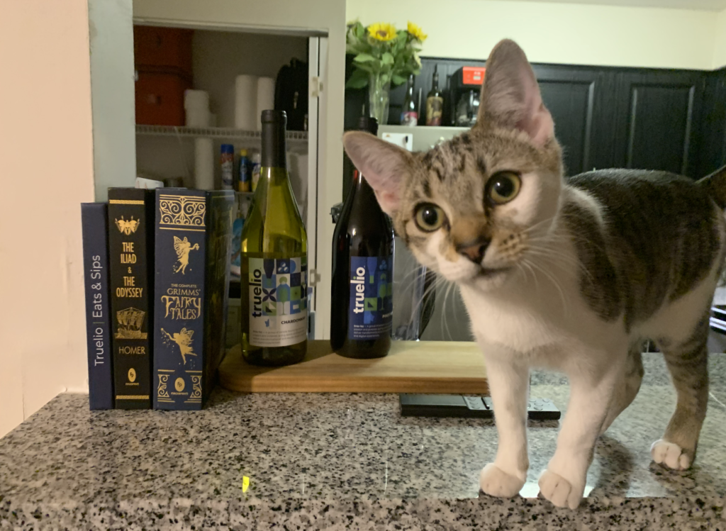 Lula on counter with Truelio wine bottles